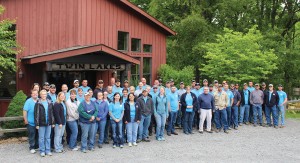 Tipmont staff members pose outside a red barn at Twin Lakes Camp.