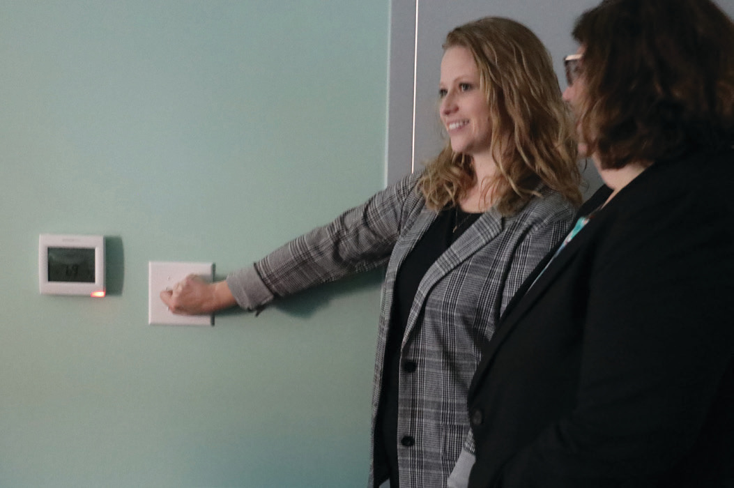 Mandy Saucerman (left) and library Executive Director Kristin Shelley flip the light switch to power up the new Hussey-Mayfield Memorial Public Library.