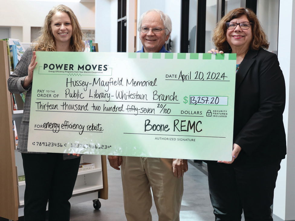 Mandy Saucerman and Alan Cragun present the Power Moves rebate check for energy efficiency upgrades in the new building to Kristin Shelley.