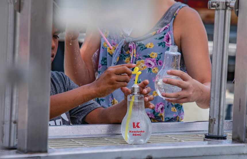 Fair-goers fill their KREMC lightbulb cups with cold water at the 2023 Kosciusko County Fair.