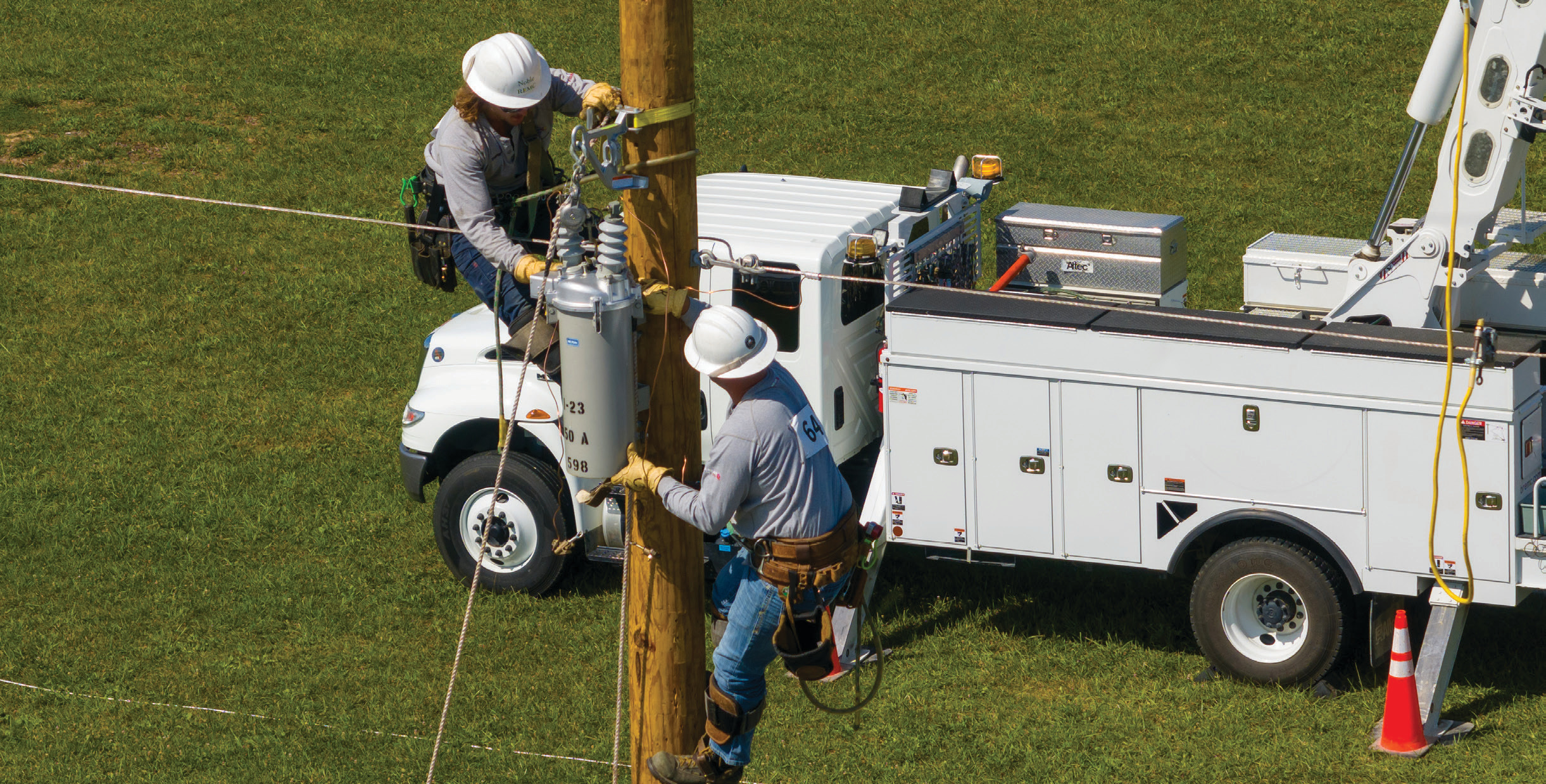 Noble REMC linemen Trevor Harlan, left, and Cody Kirkpatrick, right, work as a team during competition at the Indiana Electric Cooperative Lineman Rodeo.