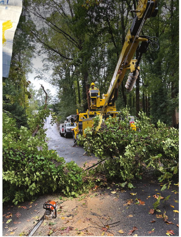 The volunteer linemen work to clear fallen trees in Georgia after Hurricane Helene.