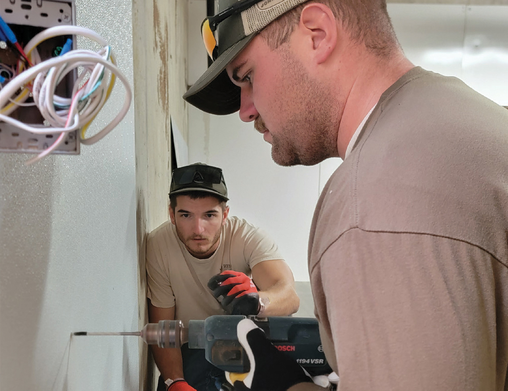 Right-of-Way Crew Members Jarrett Hawk, left, and Lane Norris work to place paneling at Kendallville Day Care Center.