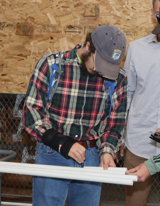 Student measures pipe at KV Trades Camp