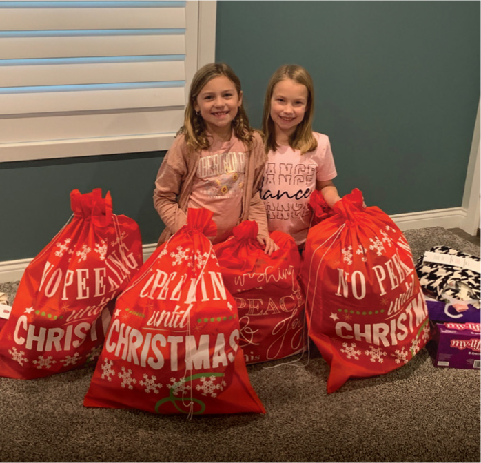 The 2024 Youth Power and Hope winners Malarie S. and Cressa K. with gifts they purchased for angel tree participants.